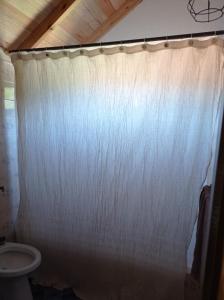 cortina de ducha blanca en el baño con aseo en Casa en Mar del Plata, Alfar en Mar del Plata