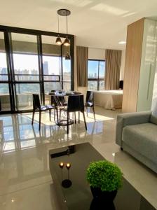 een woonkamer met een bank en een tafel en stoelen bij Estúdio Completo com Linda Vista no Ed. Vertigo in Campo Grande