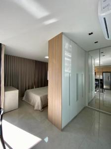 een slaapkamer met een bed en een glazen wand bij Estúdio Completo com Linda Vista no Ed. Vertigo in Campo Grande