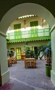 an archway in a building with benches and a balcony at La Maison du Marin in Gorée