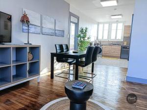 uma sala de estar com mesa e cadeiras e uma cozinha em Appartement calme lumineux proche gare 3 chambres em Angoulême