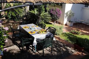 - une table avec des chaises et de la nourriture dans le jardin dans l'établissement Giardino Mediterraneo, à Ischia