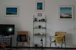 - un salon avec deux chaises et une télévision à écran plat dans l'établissement Giardino Mediterraneo, à Ischia