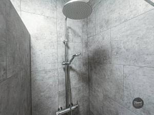 y baño con cabina de ducha con cabezal de ducha. en Appartement calme lumineux proche gare 3 chambres, en Angulema