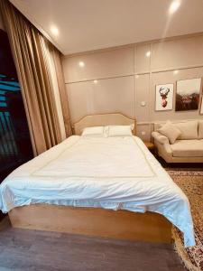 a bedroom with a large bed and a couch at NK#Homestay#Vinhomes#Oceanpark#1PN#C6 in Gia Lâm Pho
