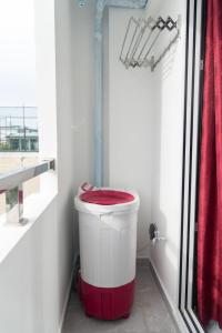 a bathroom with a red and white trash can at Resting View in Male City