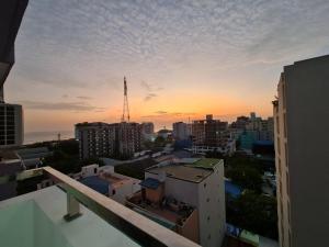 uma vista para a cidade ao pôr-do-sol a partir de uma varanda em Resting View em Malé
