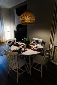 a dining room table with chairs and a chandelier at Mukava saunallinen kaksio omalla sisäänkäynnillä ja ilmaisella autopaikalla in Kuopio