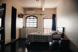 a bedroom with a bed and a window at Beira Mar Hostel & Suítes in Abraão
