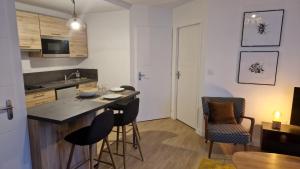 uma cozinha com um balcão e cadeiras e uma mesa em Charmant T2 proche Gare em Laval