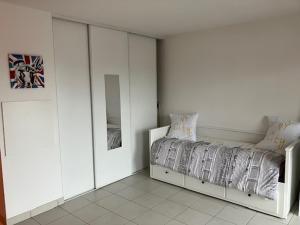 a white bedroom with a bed and a mirror at STUDIO BORDEAUX in Bordeaux