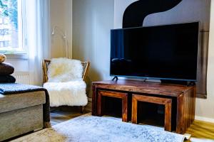 sala de estar con TV de pantalla plana sobre una mesa de madera en Mukava saunallinen kaksio omalla sisäänkäynnillä ja ilmaisella autopaikalla, en Kuopio