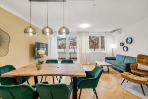 - un salon avec une table en bois et des chaises vertes dans l'établissement Vienna Chic Residences #Suite 15, à Vienne