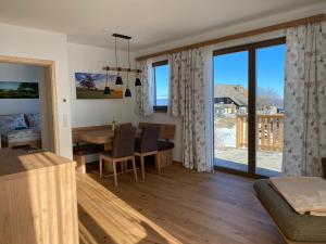 een woonkamer met een tafel en een eetkamer met uitzicht bij Berglisl - direkt an der Schipiste! Neue Ferienwohnung mit Sauna in Klippitztorl