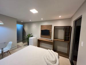 1 dormitorio con cama, mesa y TV en MarBello en Maragogi