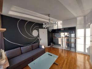sala de estar con sofá y pared con luna en Kilomètre 99 en Pont-sur-Yonne
