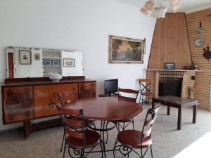 uma sala de jantar com uma mesa e cadeiras e uma lareira em Casa al Mare em Torvaianica