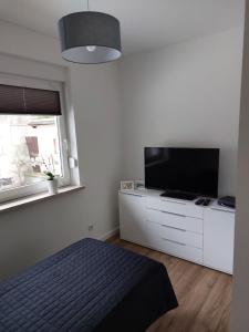 a bedroom with a bed and a flat screen tv at Ferienwohnung Rathenow an der Havel in Rathenow
