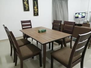 a wooden table and chairs with a box on top at KJS Homestay, Layang-Layang, Johor in Kangkar Lanjut +13 photos