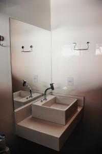 a bathroom with two sinks and a large mirror at Beira Mar Hostel & Suítes in Abraão