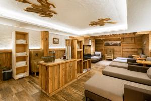 un soggiorno con pareti in legno e una camera con divani di Hotel Restaurant Hexenalm a Söll Altre 37 foto
