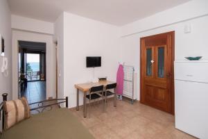 a living room with a table and a television in it at Potami Mountain in Karlovasi