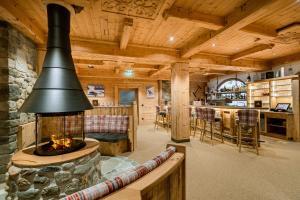 een woonkamer met een open haard in een blokhut bij Hotel Restaurant Hexenalm in Söll