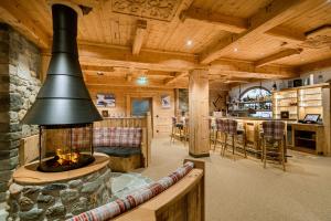 a living room with a fireplace in a log cabin at Hotel Restaurant Hexenalm in Söll