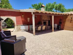卡拉瓦卡德拉克魯斯的住宿－Casa Rural Cortijo la Jimena，一个带桌椅的庭院和一座房子