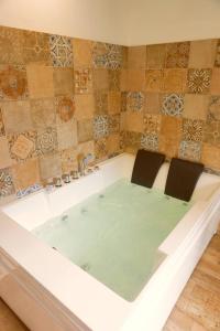 una vasca da bagno con due sedie di Mas de la Roule, 4 studios, piscine chauffée, studio SPA, parc 2 ha, Pont d'Avignon à pied ad Avignone