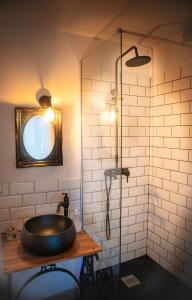 ein Bad mit einem Waschbecken und einer Glasdusche in der Unterkunft Mas de la Roule, 4 studios, piscine chauffée, studio SPA, parc 2 ha, Pont d'Avignon à pied in Avignon
