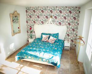 a bedroom with a bed with a blue comforter at Mas de la Roule, 4 studios, piscine chauffée, studio SPA, parc 2 ha, Pont d'Avignon à pied in Avignon