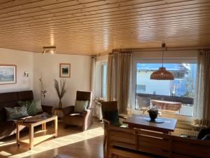 ein Wohnzimmer mit einem Sofa und einem großen Fenster in der Unterkunft Alpenflair Ferienwohnung 102 Frohnatur in Oberstdorf