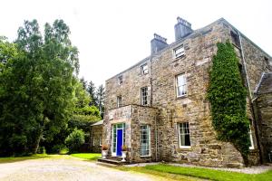 een oud stenen huis met een blauwe deur bij Dunfallandy House Hotel in Pitlochry