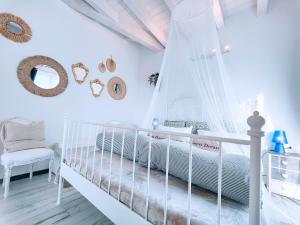バルドリーノにあるCasa Sabinaの白いベッドルーム(ベビーベッド、椅子付)