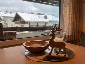 ein Rentier aus Holz auf einem Tisch neben einer Schüssel in der Unterkunft Alpenflair Ferienwohnung 102 Frohnatur in Oberstdorf