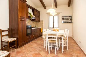 a kitchen with a table and chairs in a kitchen at Poggio ai Legni in Certaldo