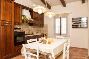 a kitchen with a white table and white chairs at Poggio ai Legni in Certaldo