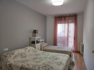 a bedroom with a bed and a window with at Apartamento Los Lirios Logroño in Logroño