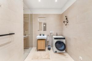 ein Badezimmer mit einer Waschmaschine und einem Waschbecken in der Unterkunft Vienna Chic Residences #Suite 7 in Wien