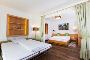 um quarto com 2 camas e uma janela em Hotel Gasthof Weiherbad em Villabassa