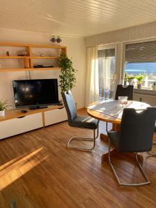 a living room with a table and a tv at Ferienwohnung Euler in Odernheim