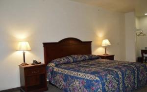 ein Hotelzimmer mit einem Bett und zwei Lampen in der Unterkunft HiWay Inn Express in Coalgate