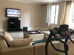 a living room with a couch and a television at Condo in a Private Resort setting King Maryout Alamriyah Governorate Egypt Comes with an outdoor private infinity swimming pool with a large garden Borg Alarb International Airport is 15 minutes- Families Only in Alexandria