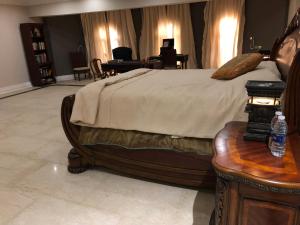 a bedroom with a bed and a table with a bottle of water at Condo in a Private Resort setting King Maryout Alamriyah Governorate Egypt Comes with an outdoor private infinity swimming pool with a large garden Borg Alarb International Airport is 15 minutes in Alexandria