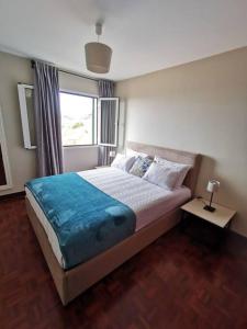 een slaapkamer met een groot bed en een raam bij Alegria A in Funchal