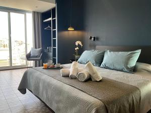 a bedroom with a bed with towels on it at Victoria by Petit Chic in Mellieħa