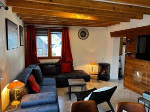 salon z kanapą i telewizorem w obiekcie Chalet des Grangettes avec jardin, sauna et Appli Roadbook - Huez w mieście LʼHuez
