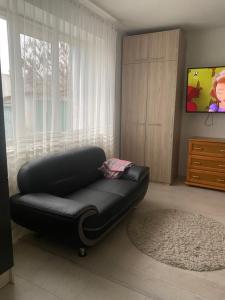 a black leather couch in a living room with a window at Квартира студіо in Luts'k