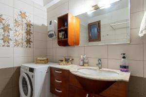 a bathroom with a sink and a washing machine at Alice house 3 in Amarynthos